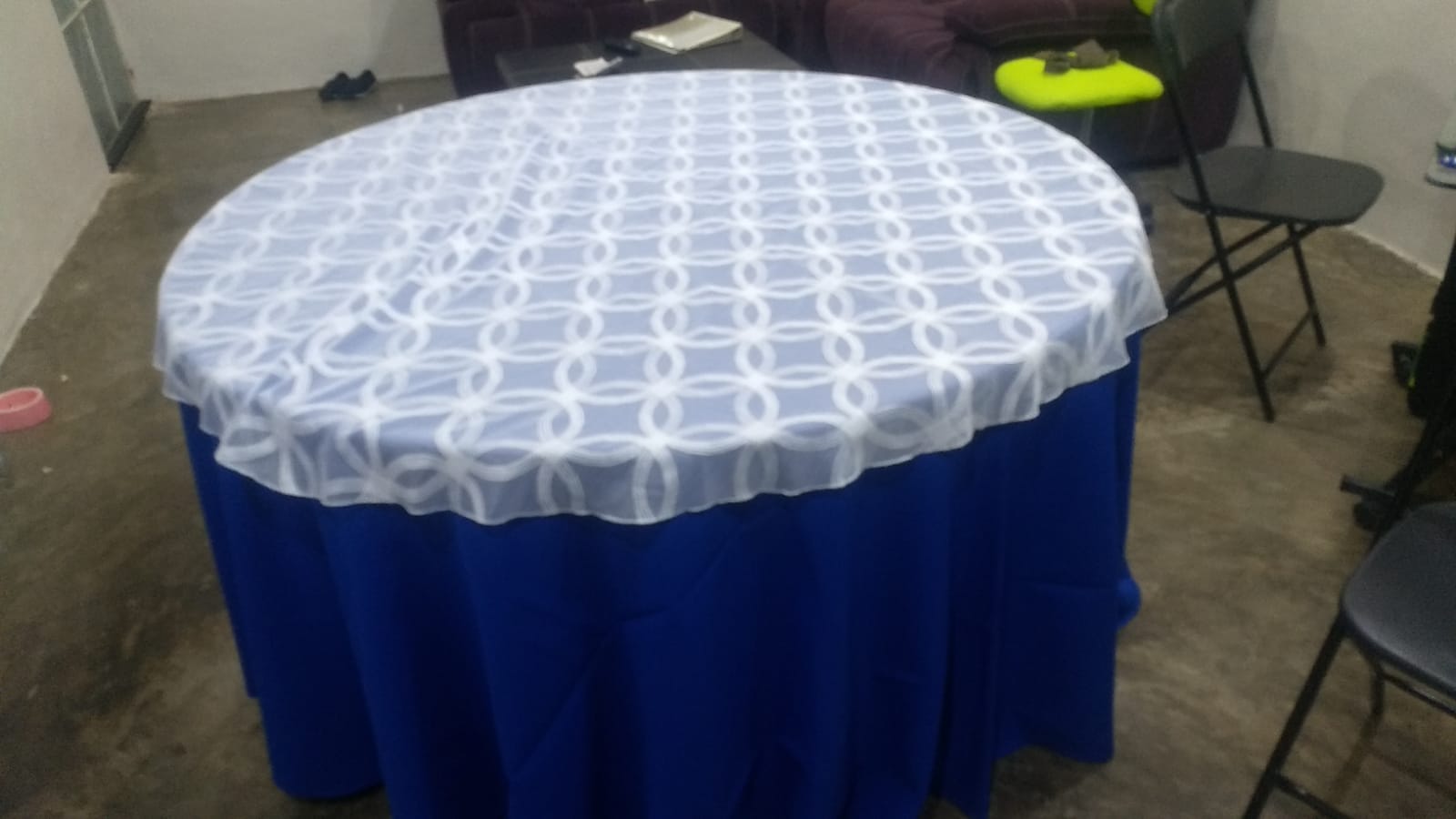 Mesa redonda con mantel azul rey y cubremantel blanco de encaje